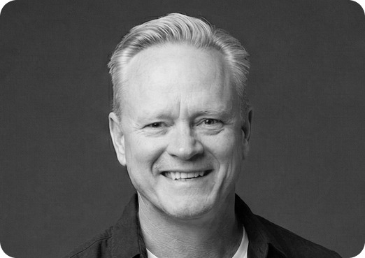 Black and white image of a man (Craig, Growth and Partnerships at Systemseed) smiling.