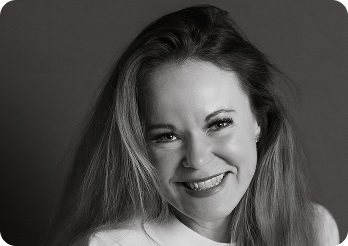 Black and white image of a woman (Freddie, CCO at Systemseed) smiling.