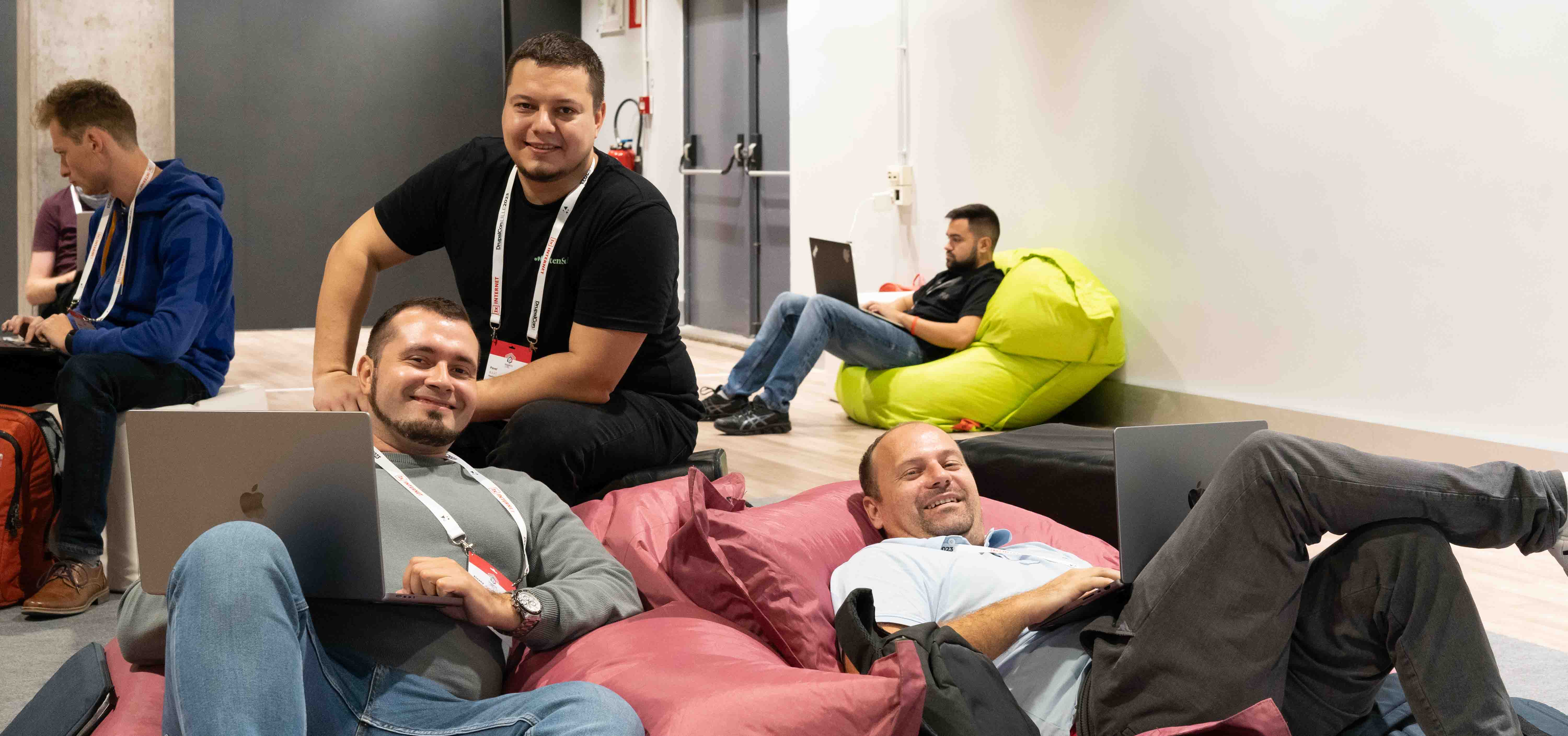 three software engineers at a conference sitting on beanbags