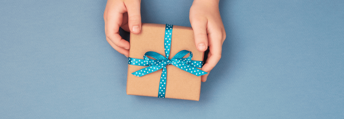 small gift wrapped in brown paper and blue ribbon on blue background