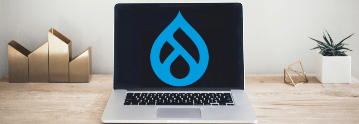 Laptop on desk with big blue Drupal logo on the screen