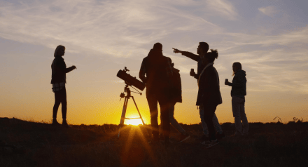 Group of people around telescope