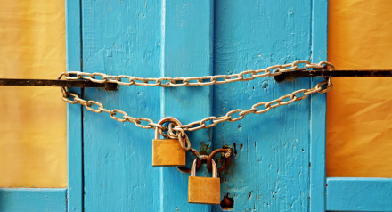 Padlocked chain on blue doors